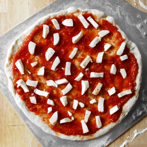 Neapolitan pizza dough topped on pizza peel