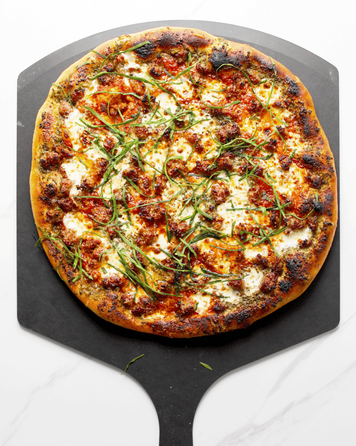 Italian sausage pizza with pesto and marinara sauce
