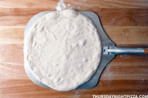 no yeast sourdough pizza dough stretched on peel